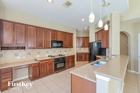 A kitchen with wooden cabinets and a granite countertop.