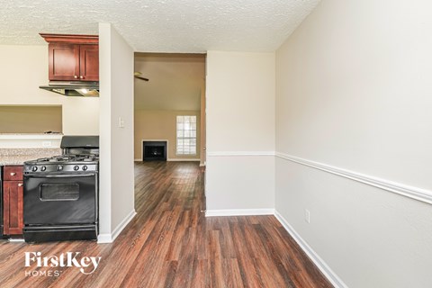 A kitchen with a wood floor and a stove top oven.