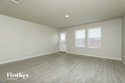 A spacious room with wooden flooring and a white ceiling.
