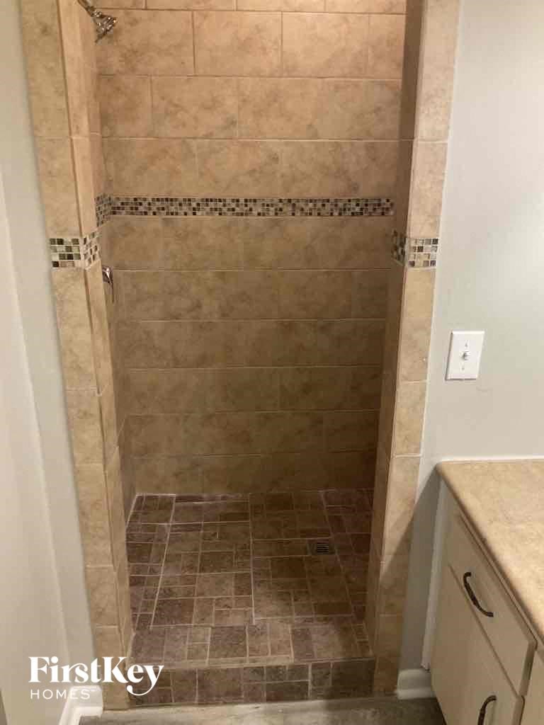 a tiled shower in a small bathroom with a sink