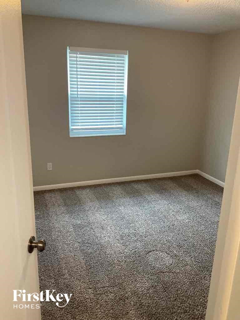 an empty room with a carpeted floor and a window