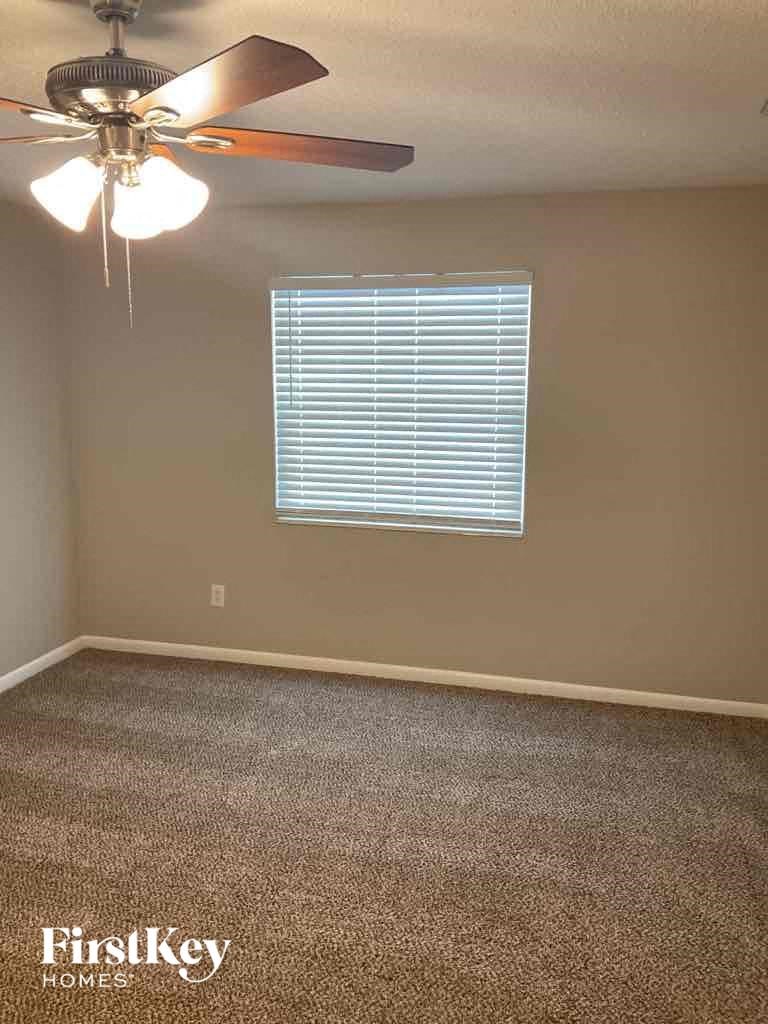 a empty room with a ceiling fan and a window