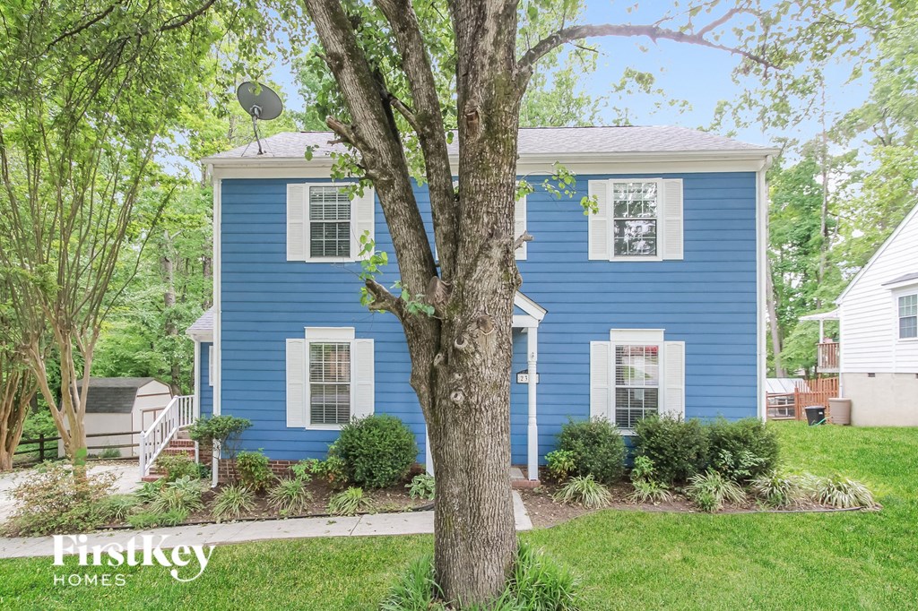a blue house with a tree in front of it