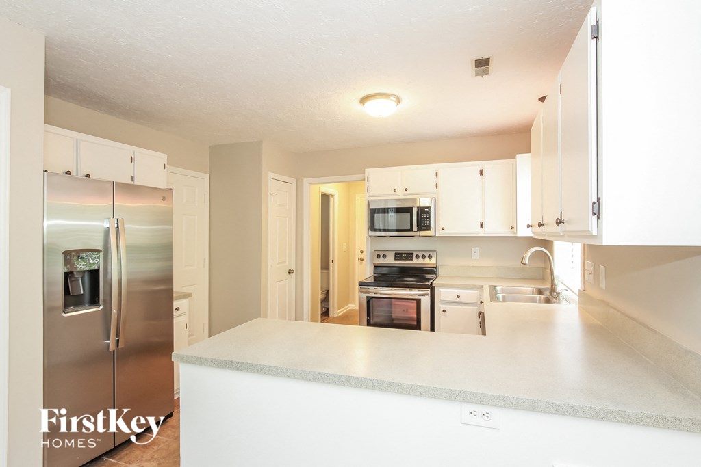 a kitchen with white cabinets and stainless steel appliances
