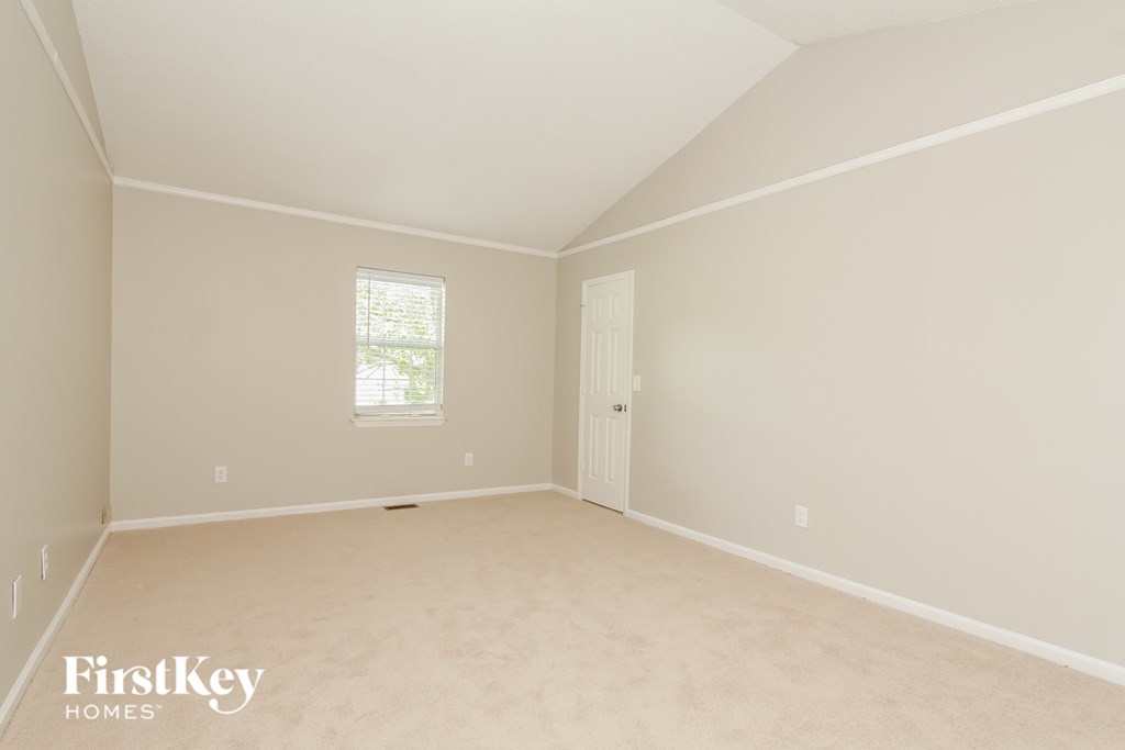 a bedroom with a carpeted floor and a white door