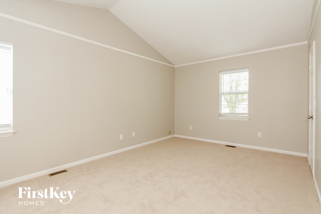 a bedroom with a carpeted floor and a window
