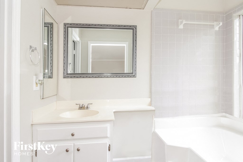 a white bathroom with a sink and a mirror