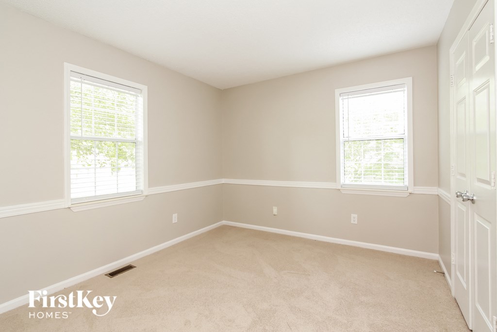 a empty room with two windows and a door