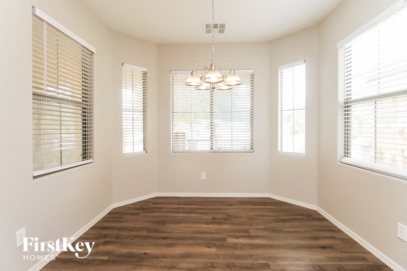 a dining room with a wood floor and a chandelier
