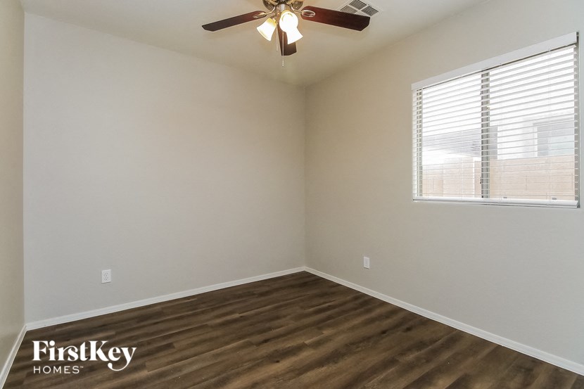 an empty room with a ceiling fan and a window