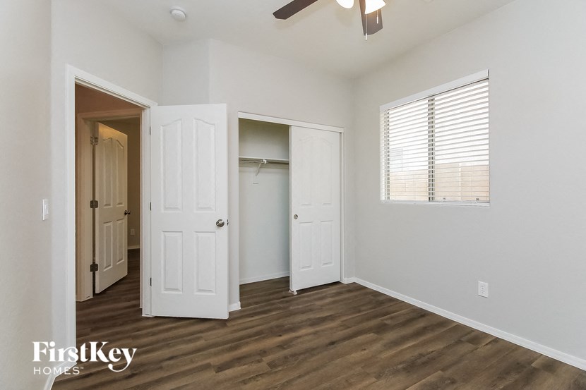 an empty bedroom with a closet and a window