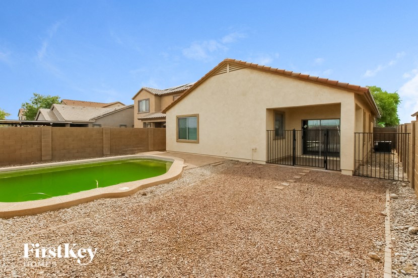 a backyard with a pool and a house with a fence