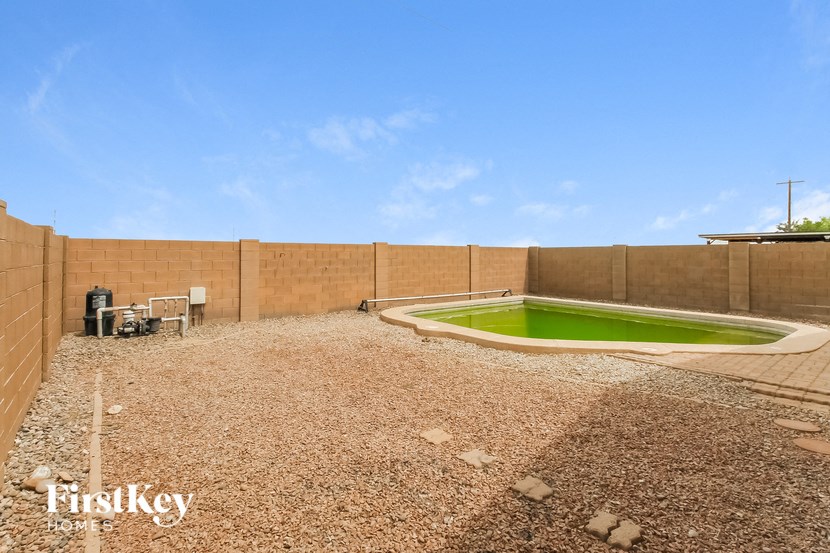 a backyard with a pool and a green lawn