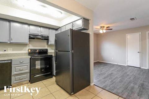 a kitchen with stainless steel appliances and a black refrigerator