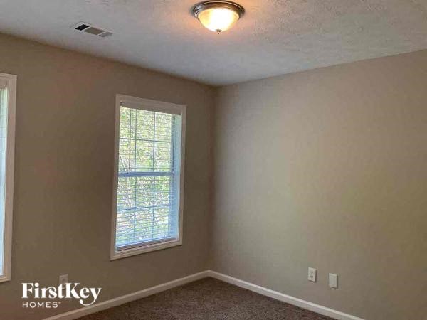 an empty room with a window and a light on the ceiling