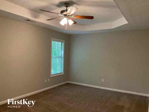 an empty room with a ceiling fan and a window