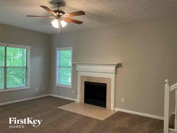 a living room with a fireplace and a ceiling fan