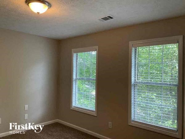 a bedroom with two windows and a light on the ceiling