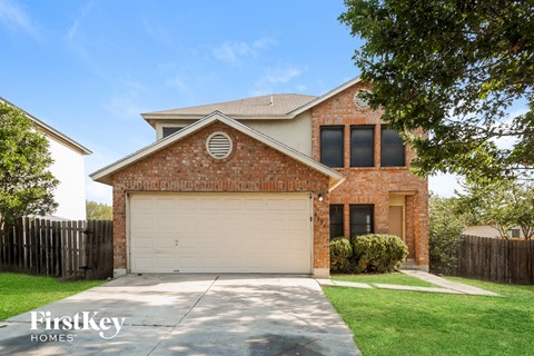 A brick house with a garage door and a sign that says "FirstKey Homes".