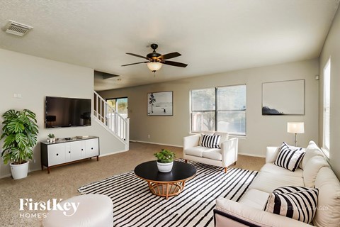 A living room with a black and white striped rug and a wooden coffee table.