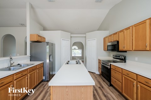 A kitchen with wooden cabinets and a white island.