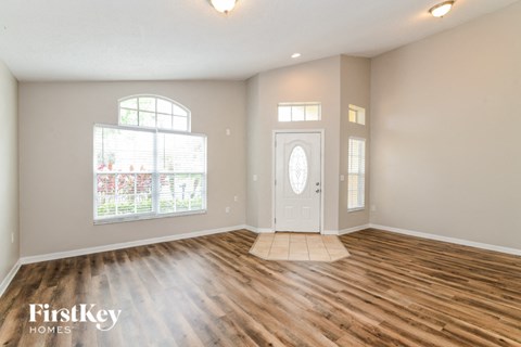 the living room of a house with a hardwood floor and a white door