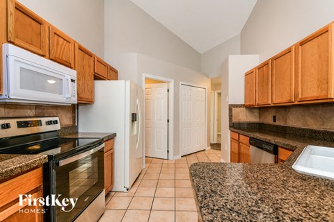 a kitchen with granite counter tops and wooden cabinets