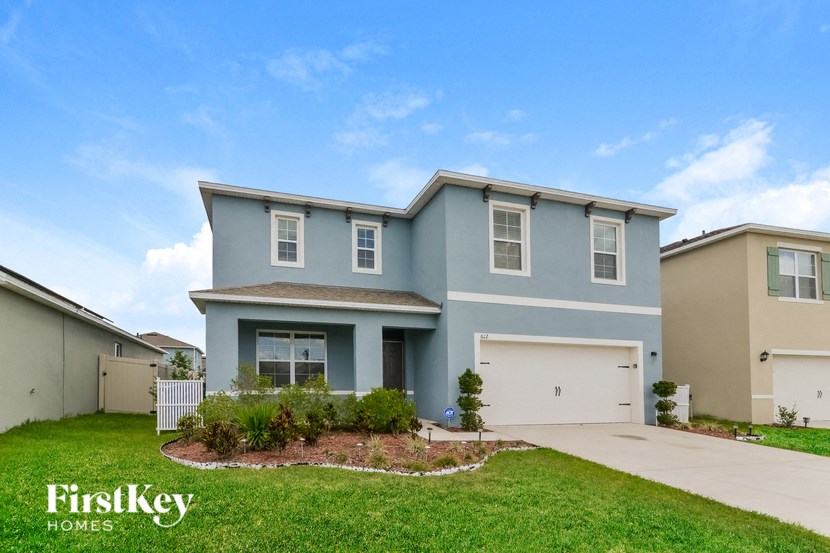 a blue house with a garage and a green lawn