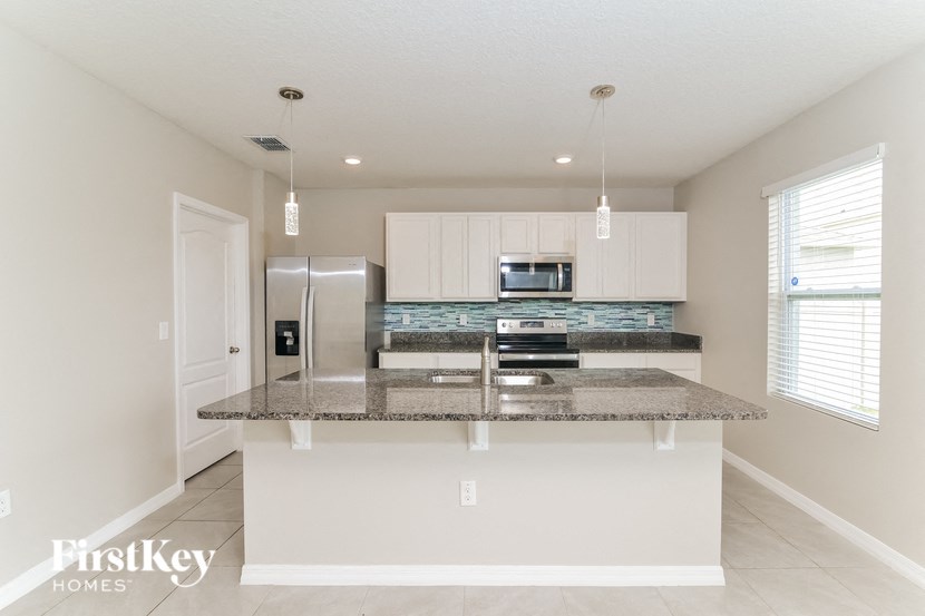 a kitchen with white cabinets and a granite counter top
