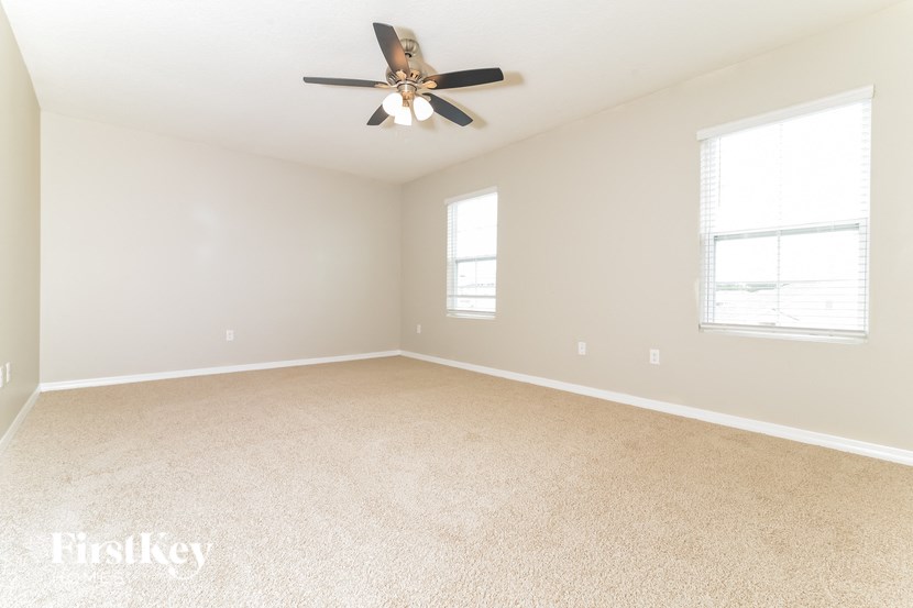 a empty living room with a ceiling fan