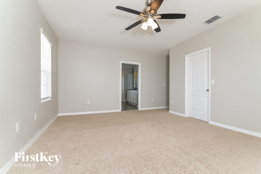 an empty living room with a ceiling fan