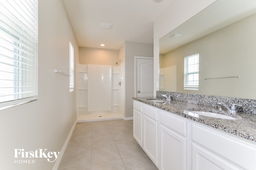 a large white bathroom with two sinks and a large mirror