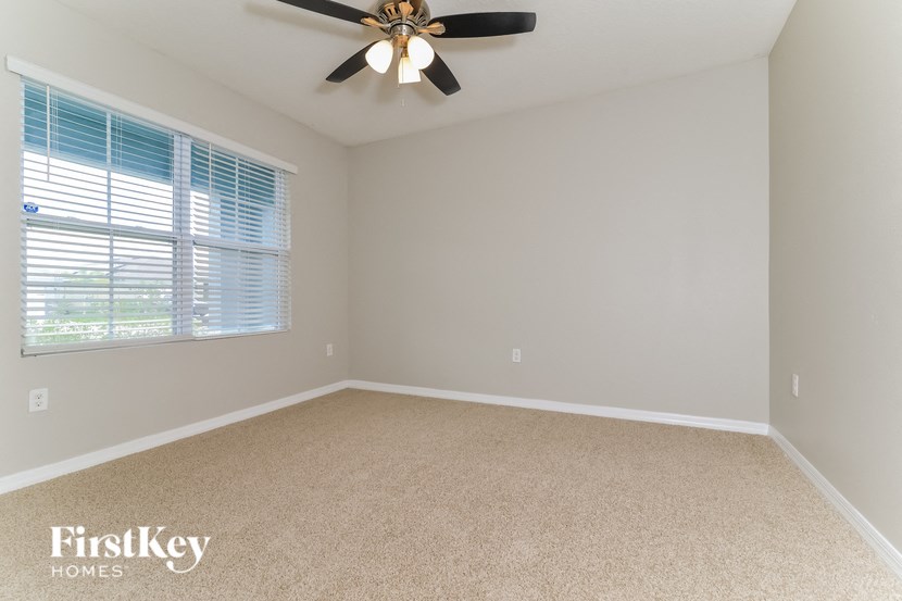 a bedroom with a ceiling fan and a window