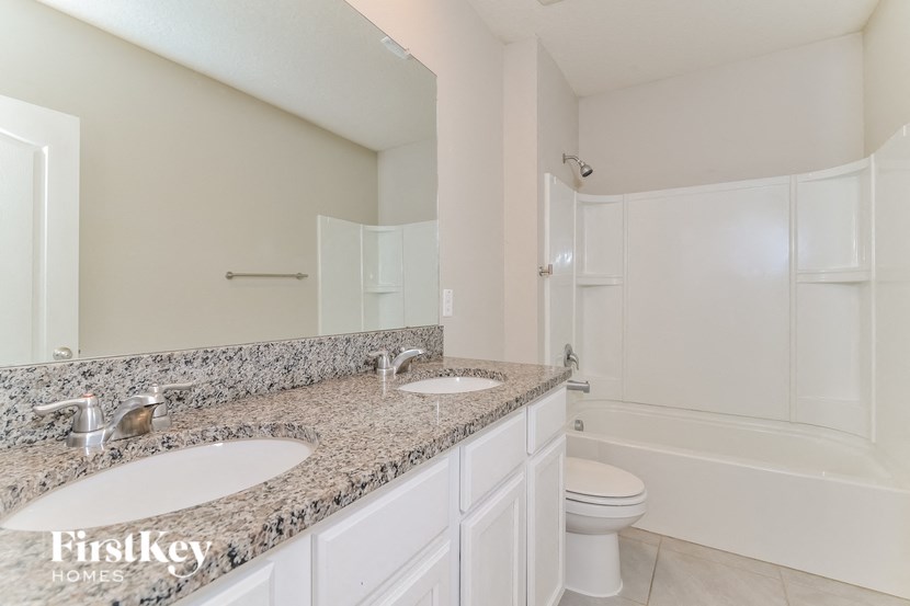 a bathroom with two sinks and a toilet and a shower