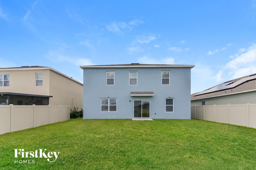 a blue house with a green lawn and a fence
