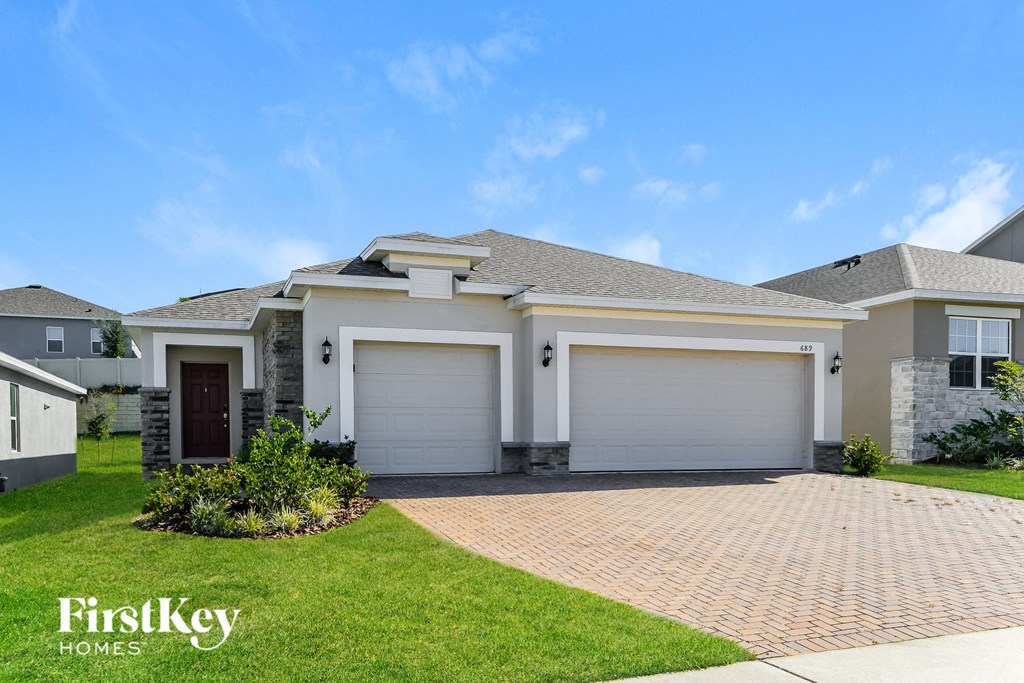 a brand new house with a garage door and a lawn