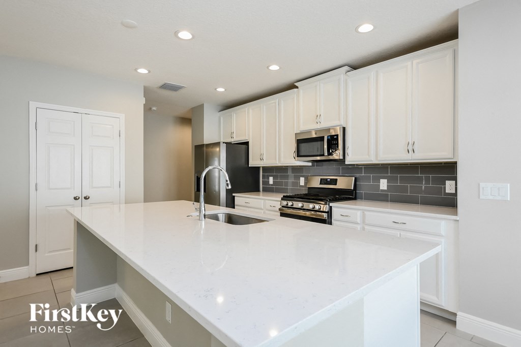 a large white kitchen with white counter tops and white cabinets