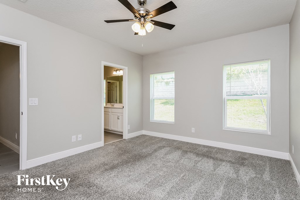 the living room of an empty house with a ceiling fan