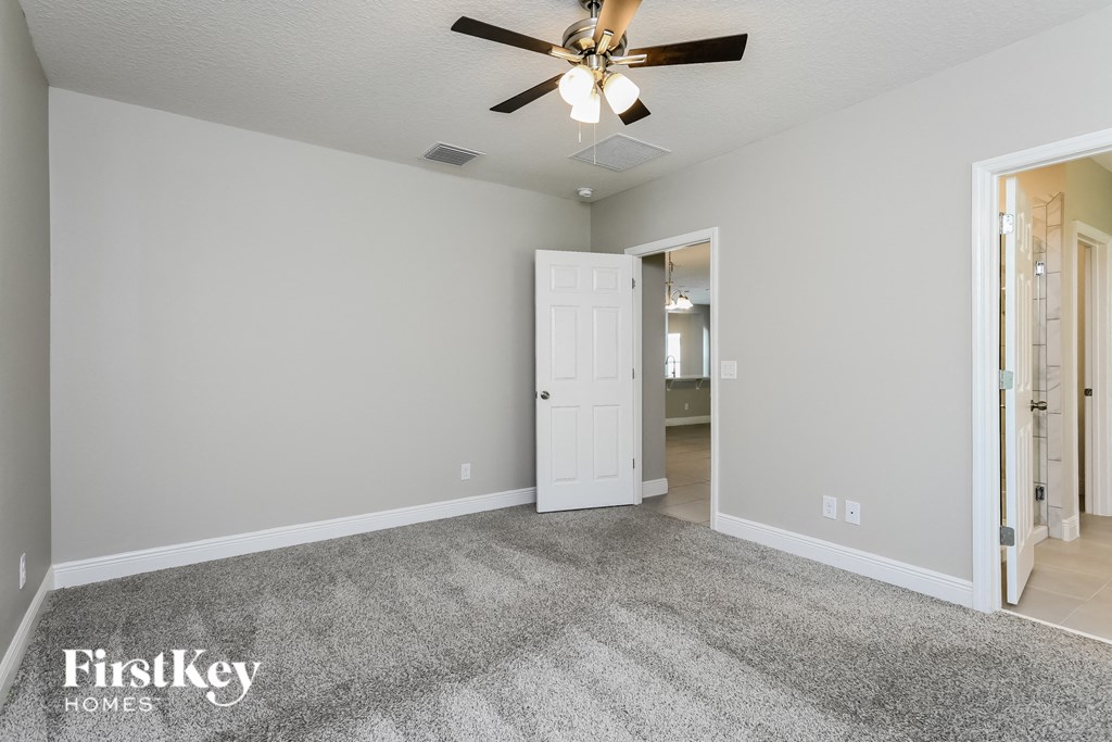 the living room of an empty house with a ceiling fan