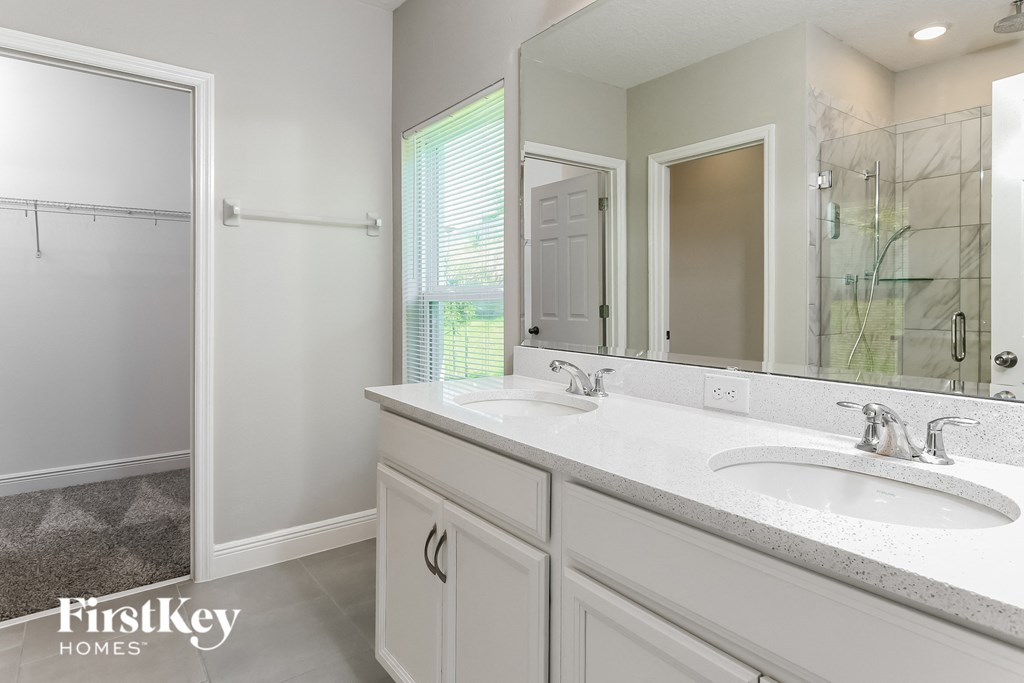 a white bathroom with two sinks and a shower