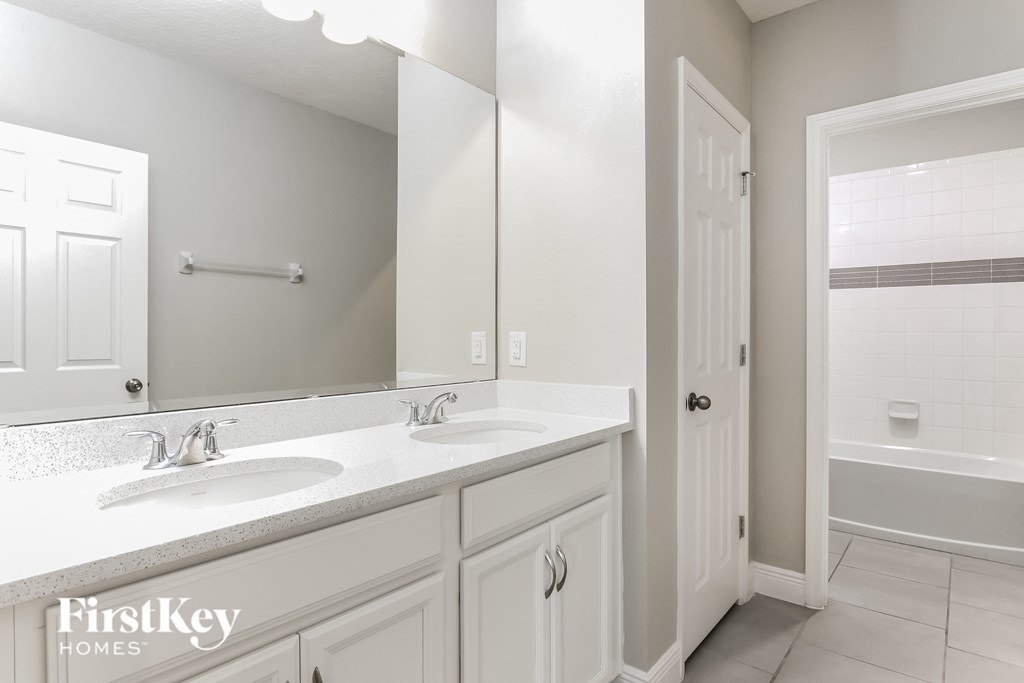 a bathroom with two sinks and a large mirror