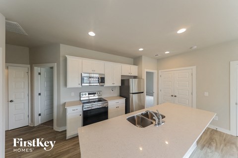 A kitchen with a sink and a refrigerator.