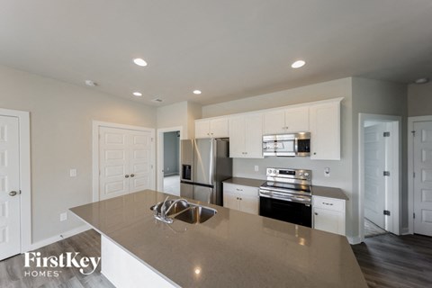 A modern kitchen with a large island and stainless steel appliances.