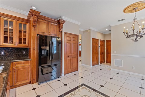 A kitchen with wooden cabinets and a black and white checkered floor.