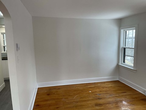 an empty room with white walls and a window