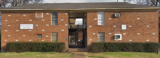the front of a brick building with a porch and a staircase