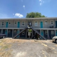 an office building with blue doors and a parking lot
