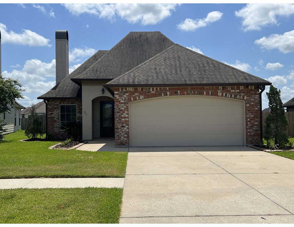 a house with a garage door in front of a lawn