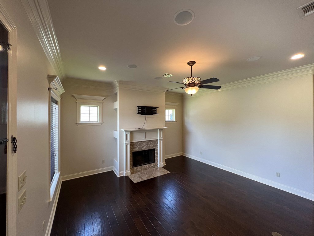 a living room with a fireplace and a ceiling fan
