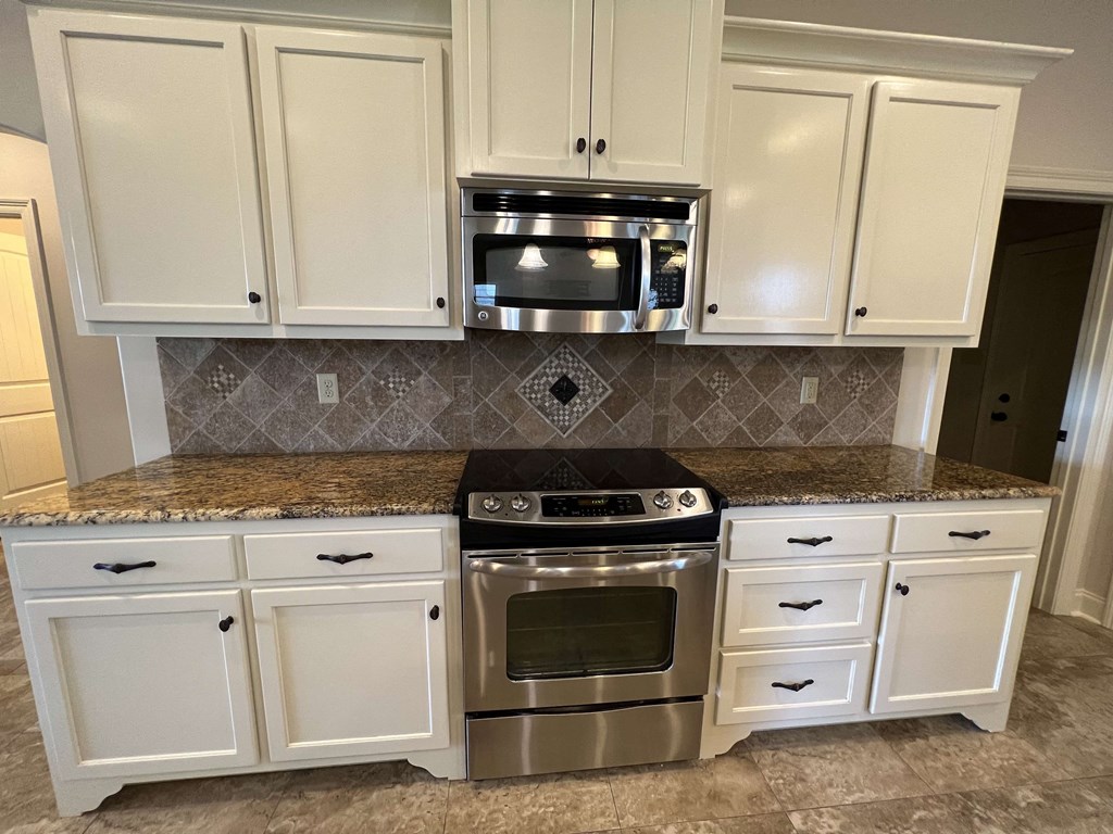 a kitchen with white cabinets and stainless steel appliances